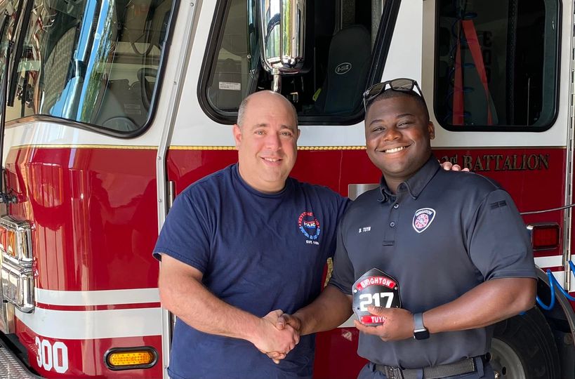 Firefighter Ben shaking hands with member with his sheild